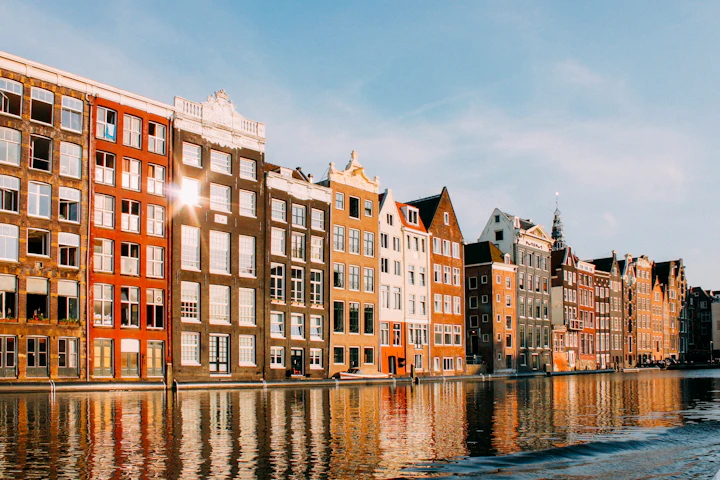 Colorful canal houses lining a waterway in Amsterdam, Netherlands.